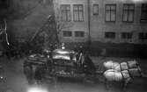 Kistan placeras i vagnen för en likfärd genom stan, 1930-tal