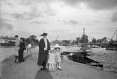 Mor med barn vid hamnen, 1920-tal