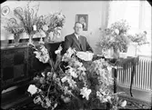 Elmontör Valdemar Johansson omgiven av blommor, Gimo, Uppland