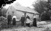 Emanuels, Sällstorp. Fem vuxna och ett litet barn står utanför stugan; fr v. Johan och Alma (Dala), Emanuel och Augusta, lille Artur och Evelina.