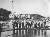 Strömnäs sågverk. Personer: 1. John Eriksson; 2. Jonas Ramström; 3. Herman Wallin?; 4. Otto Vestman; 5. Martin Sundin?; 6. Ture Wallin; 7. Evert Olsson; 8. Otto Vikström; 9. Fritz Nylén; 10. Sigvard Sundin; 11. Birger Nyberg; 12 Torvald Sundin; 13 Leo Olsson