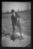 En man tar upp vatten ur en brunn, med hjälp av en hink.