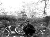 En man med cykel lagar vad som ser ut att vara en punktering.