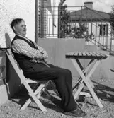 Man sittandes i trädgårdmöbler.