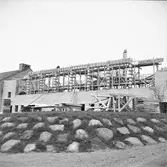 Hagaskolans nya gymnastikbyggnad i Varberg, kv Orren 1. Bild 1 visar byggnaden och på bild 2 sitter ett par män vid ett mötesbord. Artikel i samband med bilden publicerad i Varbergs Tidning 1958-05-21.