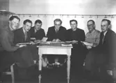 Studiecirkel SLS. Gruppen är samlad i bastuns omklädningsrum. Studieledare är Nils J. Wedin, Övered. Personer:; 1. Per Melander, Träsk f. 1923-03-15; 2. Kurt Stocksén, Träsk f. 1925-03-15 d. 1991-04-24 i Uppsala. 3. Erik Axel Hägglund, Träsk f. 1909-06-16; 4. Nils J Wedin, Övered f. 1925-04-19 d. 1976-07-31. 5. Folke A Lockner, Träsk f. 1920-08-08; 6. Hildemar E Höglin, Träsk f. 1910 d. 1953; 7. Karl Stattin, Träsk f. 1912-02-03 i Bjärtrå.