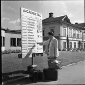 Kerstin Åsén tittar på tågtiderna på Falköpings station. Hotell Ranten syns bakom henne.