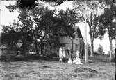 Familj i trädgården utanför bostadshus, Östhammar, Uppland