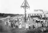 Ringlekar kring midsommarstången 1932 på Kustsanatoriet Apelviken. Några har folkdräkter på sig.