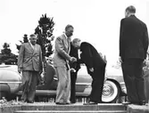 Kung Gustav VI Adolf på Eriksgata genom Halland, då han besökte Kustsanatoriet Apelviken i Varberg. Här välkomnas han av sanatoriets bugande överläkare Albert Ahlberg. Bakom honom står intendent Harald Liljenberg och vid bilen syns Hallands landshövding Reimer Johansson. (Se även bildnr KSA41-47)