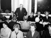 Landshövding Reimer Johansson står och håller tal vid invigningen av det nya köket 1959 på Kustsanatoriet Apelviken. Förste mannen till höger om honom är överläkare Albert Ahlberg och hans hustru Frida sitter till vänster om landshövdingen.