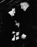 Emy Stilling, städerska/baderska på Kustsanatoriet Apelviken, tar emot en medalj ur landshövding Reimer Johanssons hand.