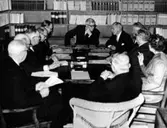 Styrelsesammanträde för Kustsanatoriet Apelviken. Ordförande landshövding Reimer Johansson i bildens mitt samtalar med sanatoriets överläkare Albert Ahlberg till höger.