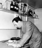 En man som arbetar i fotolaboratoriet på Kustsanatoriet Apelviken, där röntgenfilmer framkallas. (Se även bildnr KSA72)