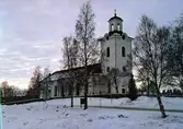 Nätra kyrka. Vykort. Byggmästare Simon Geting. Vitputsad stenkyrka med torn. Nyklassicistisk stil. Inredning i början av 1800-talet. Altarväggen utformades 1847-48 av Olof Hofrén. Predikstol från 1814. Grundläggningsarbetet påbörjades 1805 och byggnationen, som krävde stora mängder sten för de två meter tjocka murarna, innebar stora uppoffringar från församlingsmedlemmarnas sida. En vall av jord lades upp runt murarna för att man med stenslädar och hästar skulle kunna föra upp materialet. På hösten 1807 var kyrkan så pass färdigställd att man kunde hålla gudstjänst och invigningen skedde den 27 november av prosten Anders Lundström i Sidensjö. En mer högtidlig invigning med biskop Erik Abraham Almquist skedde inte förrän tio år senare, den 6 juli 1817. 