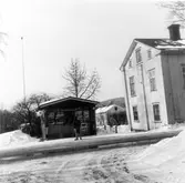 Mellan kiosken och nr 16 syns huset på Östanbäcksgatan 24 i Kv Smeden. Huset har nu vänts vinkelrätt mot Östanbäcksgatan och lyfts upp på vagnar för att rullas iväg till Murberget.