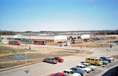 Buss och bilparkering vid MM- och veteranbilsmässa i Vivalla företagsby på Boglundsängen, 1982