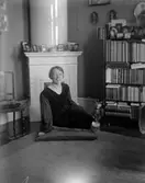 Kvinna framför kakelugn, 1921