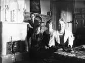 Familj vid kakelugn, 1927