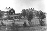 Den vänstra byggnaden tillhörde Johannes och Gertrud Vallin. I den högra bodde Axel Böhlin. Husen revs omkring år 1900.