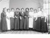 Tio unga kvinnor står arm i arm. (Se även bildnr MR2_1044)