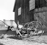 Tallfrösåningsmaskin uppställd vid en ekonomibyggnad på gården Vallen, Våxorp.