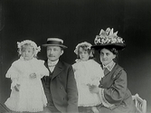 Porträtt beställt av Dahlberg med sittande man och kvinna med två stående små flickor i spetsklänningar. Alla bär huvudbonader, kvinnans hatt är rikt dekorerad.