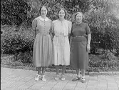 Tre kvinnor fotograferade vid en rabatt, troligen utanför Ranchs Atelier. Belden beställd av Svea Gustavsson.