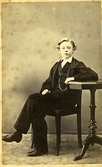 Fotografi från August Bondesons vänkrets. Ateljeporträtt av en ung gosse i kostym med fickur.