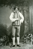 Ateljéporträtt av en ung August Bondeson i dräkt från mellersta Halland, så som han uppträdde på soiré då han berättade sagor och historier.