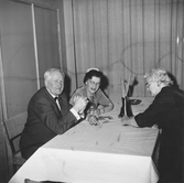 Två damer och en man vid ett bord, 1940-tal