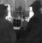 Besökare vid kyrklig ceremoni i Ödeby kyrka, 1950-tal