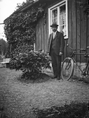 Man framför hus i Glanshammar, 1920-tal