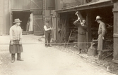 Magasinskarlar hugger av järnstänger vid P O Jonssons järnhandel, Södra Strandgatan 5, 1912