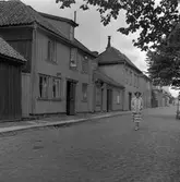 Kerstin Åsén promenerar på östra änden av Kanalgatan i Jönköping. Längst gatan ligger trähus där fönstren står öppna för vädring.
