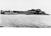 Vy från havet mot Varbergs fästning och kallbadhus med datering från 1909.