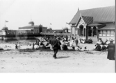 Badliv i Varberg under tidigt 1900-tal med många badgäster mellan kallbadhuset till vänster och varmbadhuset till höger. Fotograferat troligen efter 1912.