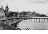Varbergs varmbadhus från 1866 med bron ut till kallbadhuset. I bakgrunden syns fästningen.