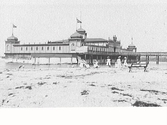 Kallbadhuset från 1903 med badande människor på Barnens badstrand.