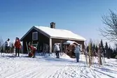Skidåkare rastar vid stugan, 1987