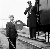 Kondoktör samtalar med stinsen på Kilsmo station, 1960-tal