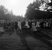 Flickor bär på midsommarkransar i Brevens bruk, 1960-tal