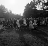 Flickor bär på midsommarkransar i Brevens bruk, 1960-tal