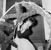 Kvinna med krans till midsommarstången i Brevens bruk, 1961