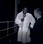 Floyd Pattersson i ringen, talar i mikrofon. Pattersson, som mött svensken Ingemar Johansson flera gånger, var mycket populär i Sverige och gjorde flera uppvisningsturnéer.