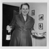 Kvinna med champagne och korv med bröd, 1950-tal