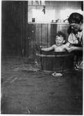 Mamma badar sitt barn i köket, 1940-tal