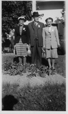 Grupp bakom blomsterrabatt, 1940-tal