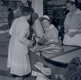 Bild tagen i samband med invigning av Konsum. Kvinnor vid kassan.