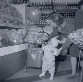 Bild tagen i samband med invigning av Konsum. En kvinna och barn med ballong.